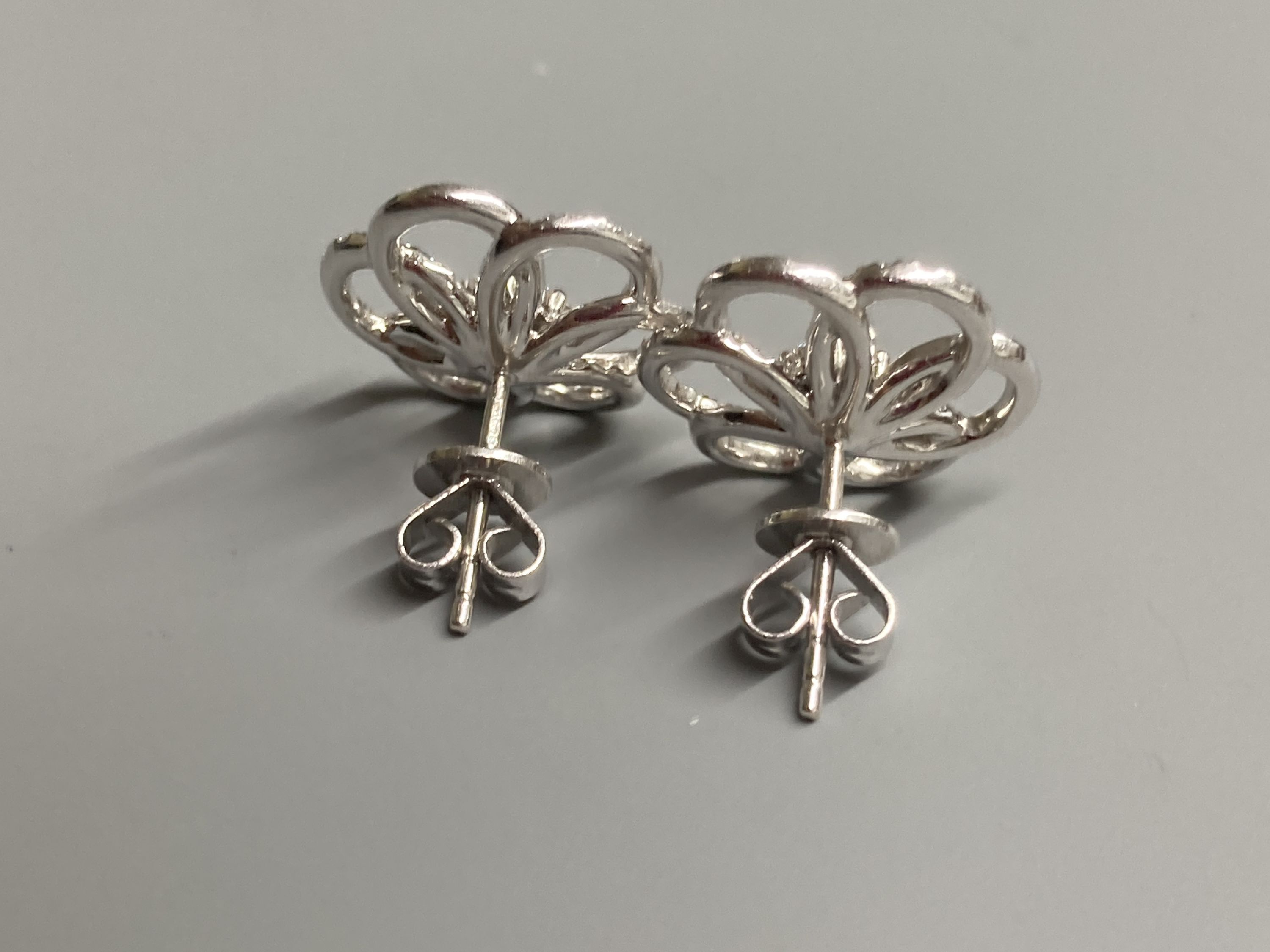 A modern pair of 18ct white gold and diamond cluster set openwork flower head ear studs, diameter 16mm, gross weight 4.4 grams.